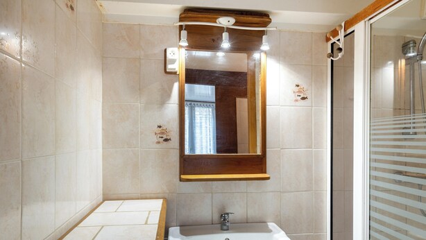 A bathroom with a sink, mirror, and shower. - Homerez - House in Beuzec-Cap-Sizun (Beuzec-Cap-Sizun)