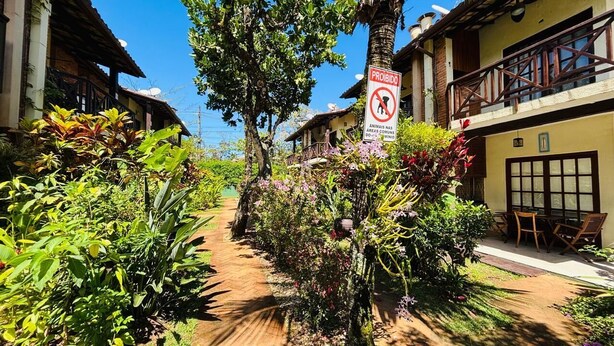 A pathway lined with lush greenery and a 'Proibido' sign indicating no animals allowed. - 2 bedrooms, 1 suite, 2 bathrooms, 100 m from the best location in Praia da Baleia. (São Sebastião)
