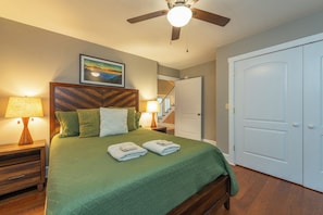 A bedroom with a bed, a ceiling fan, a nightstand with a lamp, and a door. - Hot Tub+Fire Pit, Mtn Sunsets, Fireplace & Grill! (Spruce Pine)