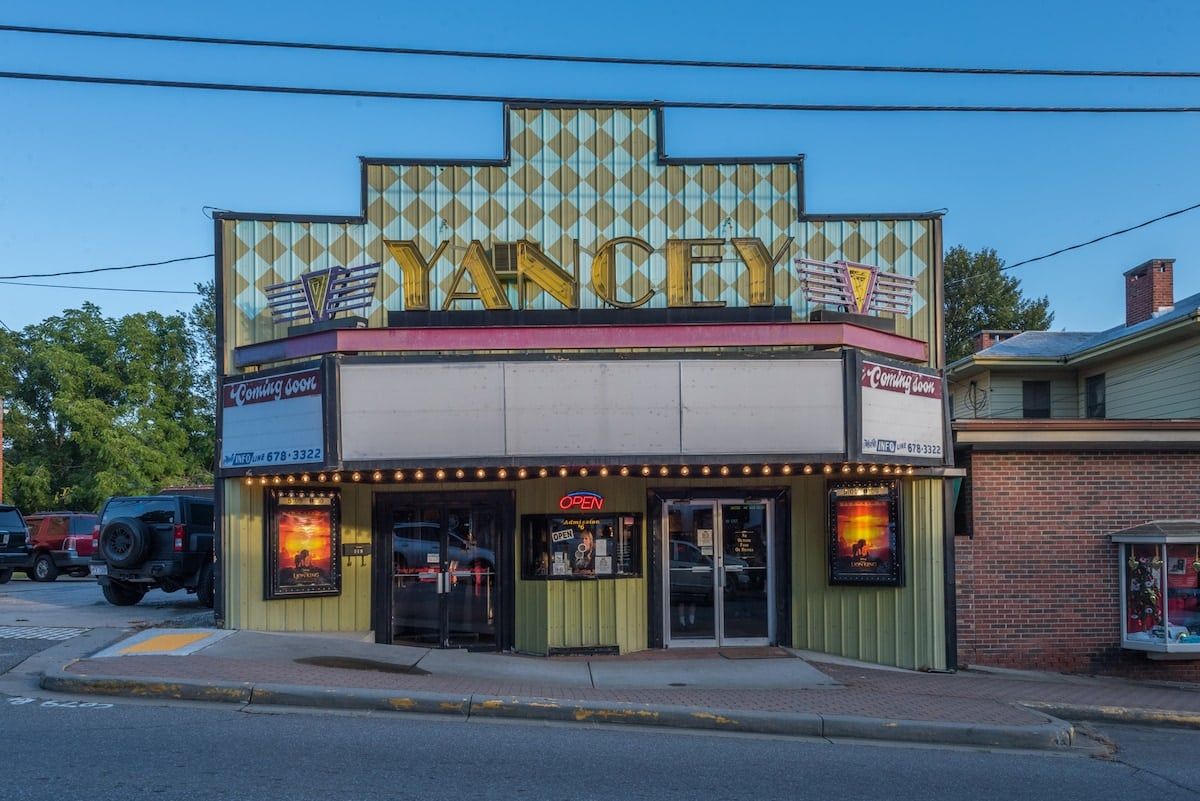 Un teatro con un cartel luminoso que dice 'YANCEY' y un letrero que indica 'Próximamente'.