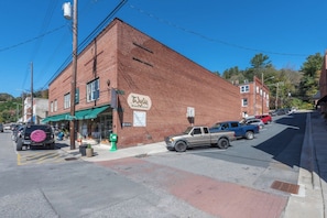 A brick building with a green awning and a sign that reads 'Wylie Building.' - Hot Tub+Fire Pit, Mtn Sunsets, Fireplace & Grill! (Spruce Pine)
