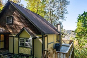A cabin with a deck, a chimney, and a window. - Hot Tub+Fire Pit, Mtn Sunsets, Fireplace & Grill! (Spruce Pine)