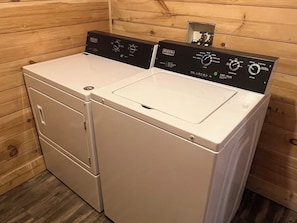 A compact, two-door washing machine with a control panel, situated in a wooden room. - Hot Tub+Fire Pit, Mtn Sunsets, Fireplace & Grill! (Spruce Pine)