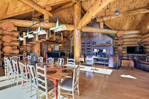 Amplio interior de cabaña de madera con comedor, cocina y sala de estar.