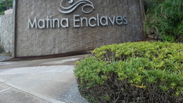 A sign for 'Matina Enclaves' with a landscaped area in front. - Affordable Luxury 2BR Condo in Davao City (Davao City)