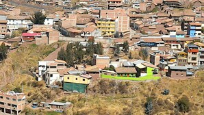 A densely packed residential area with closely built houses, some with sloped roofs, and a few modern buildings with flat roofs. - ewwwwwwwww (Cusco)