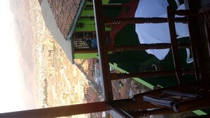 A view through a window with wooden beams, a green wall, and a white curtain. - ewwwwwwwww (Cusco)