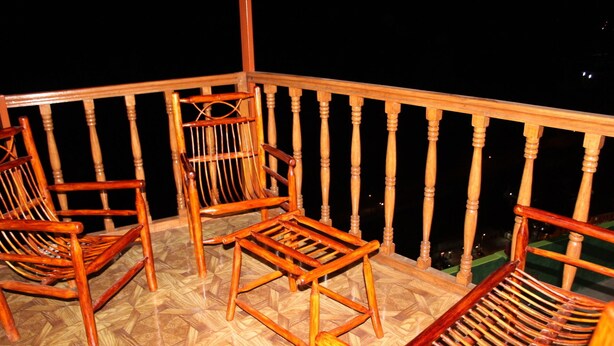 A balcony with wooden chairs and a table. - ewwwwwwwww (Cusco)