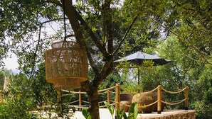 An outdoor seating area with wicker chairs and a table set with plates of food and glasses. - Guest Room in nature in Minorca : Adults Only (Ferreries)