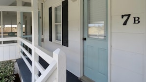 A white building with a light blue door marked "7B".