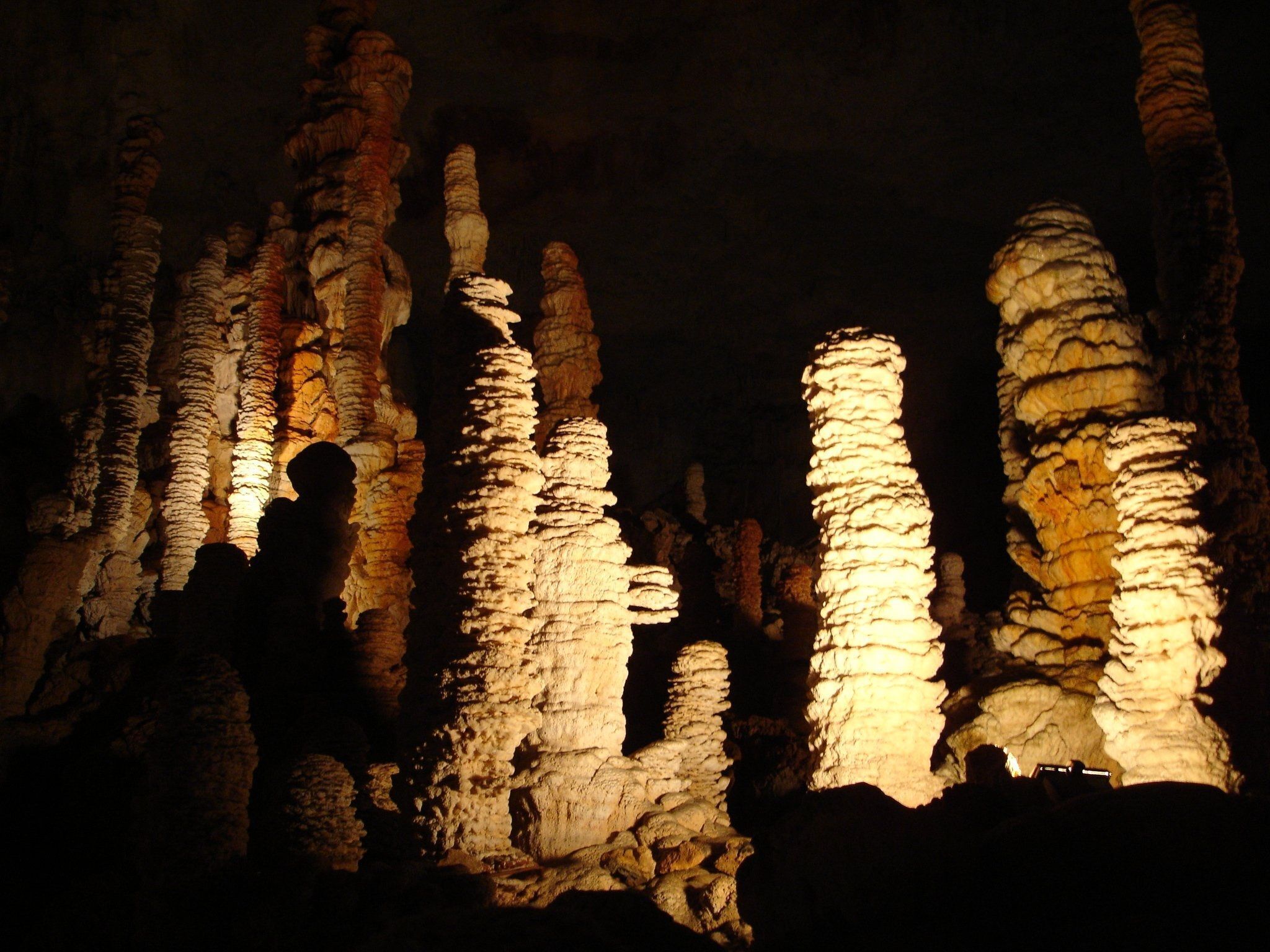 A cave with illuminated stalactites and stalagmites.