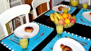 A compact kitchen with a dining table set for breakfast.