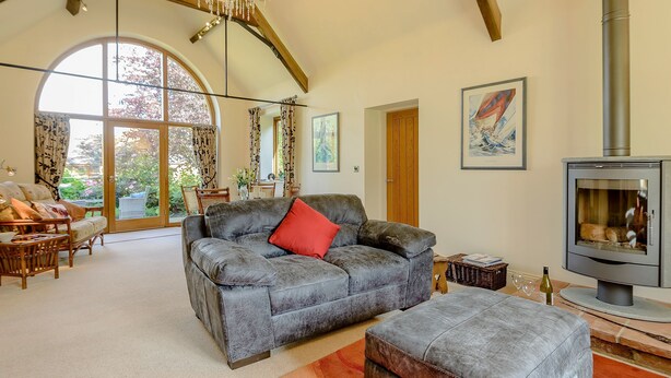 A spacious living room with a fireplace, a sofa, and a dining area. - 1 bedroom accommodation in Rufford, near Newark (Rufford, near Newark)