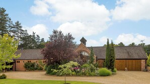 A brick building with a large garage and a covered driveway. - 1 bedroom accommodation in Rufford, near Newark (Rufford, near Newark)