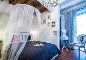 A bedroom with a canopy bed, a mannequin, and a chair. - Abbraccio di Romeo e Giulietta (Verona)