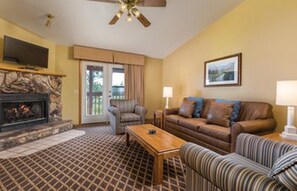 Cozy living room with a fireplace, comfortable seating, and a TV.