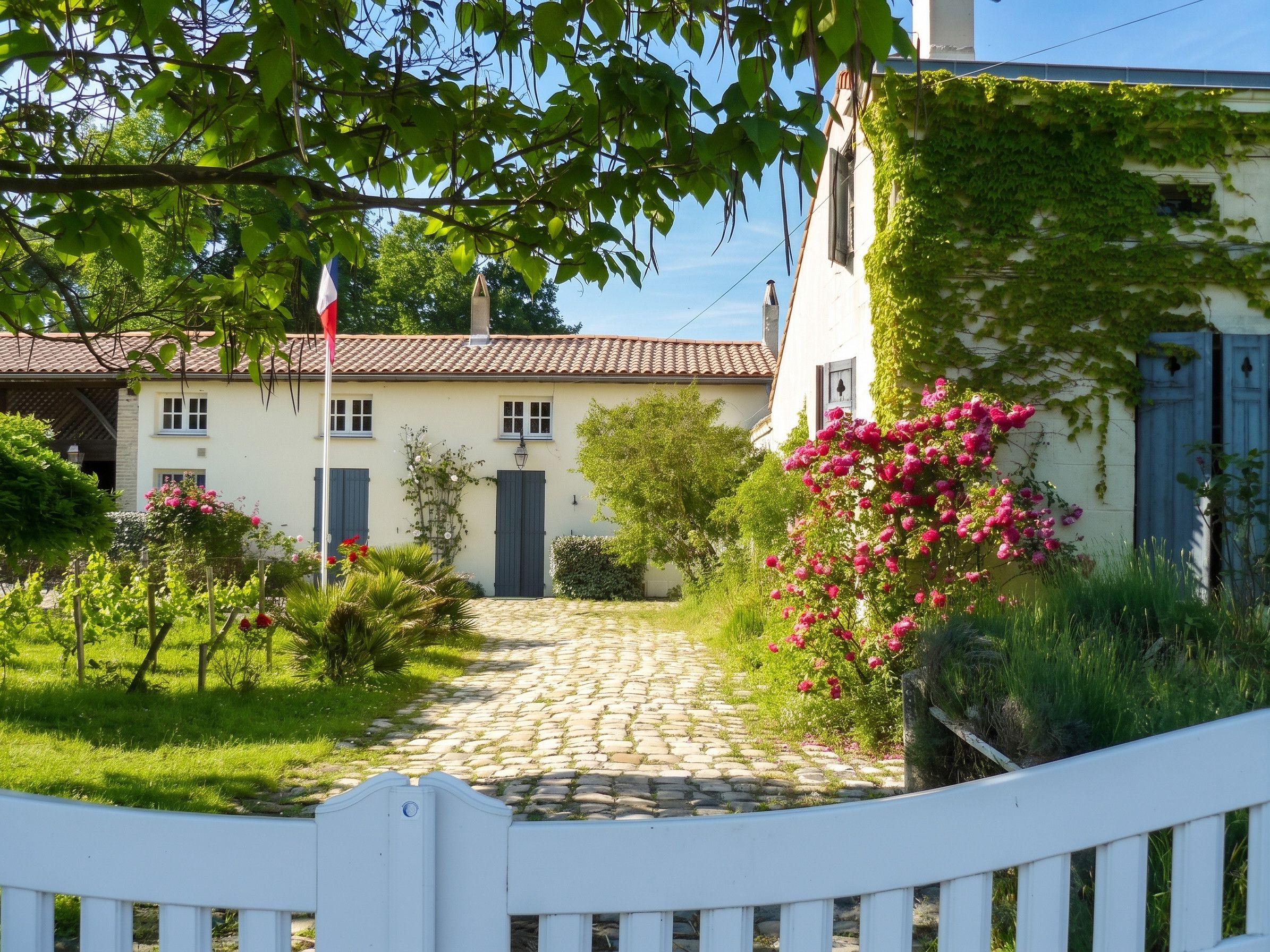 Un bâtiment traditionnel avec un toit en tuiles, un drapeau et un chemin pavé menant à l’entrée.