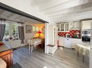 A kitchen with white cabinets, a red and beige tiled backsplash, and modern appliances. - Homerez - Villa in Arsac with pool (Arsac)