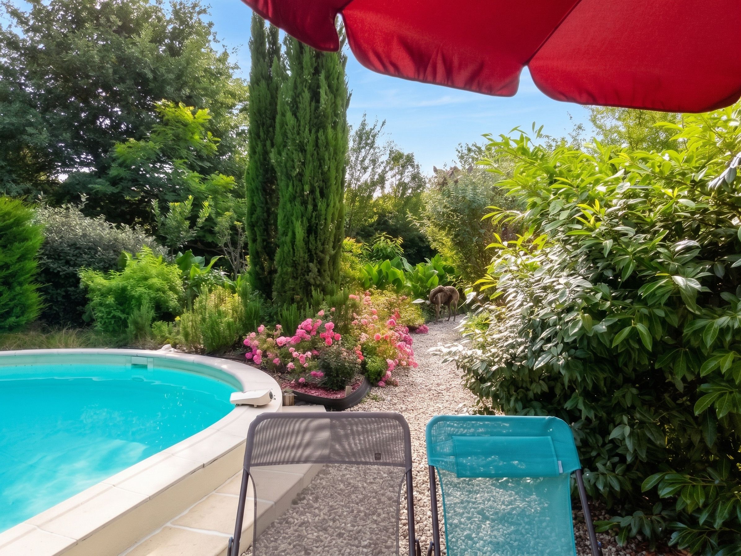 Une piscine avec des chaises longues et un parasol rouge.