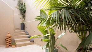 A staircase with a potted plant, a lantern, and a wall-mounted light fixture.