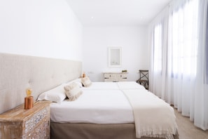 A spacious bedroom with a large bed, a wooden nightstand, a white dresser, and a chair. - THE VICTORY HOUSE. (Garachico)