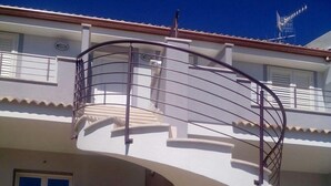 Un edificio a due piani con una scala a chiocciola che conduce al piano superiore.