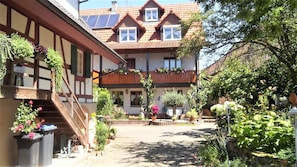 Un edificio de estilo europeo tradicional con un patio interior, balcones de madera y plantas en macetas.