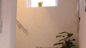 A staircase with a white wall and a small window at the top. - Apartment Hug - Apartment, 4 bedrooms, from 5 persons, max. 7 people (Ringsheim)