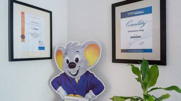 A framed certificate on the wall, a framed award, and a plush toy.