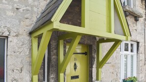 A building with a green door and a small window with flowers. - 3 bedroom accommodation in Arnside, near Grange-over-Sands (Arnside, near Grange-over-Sands)