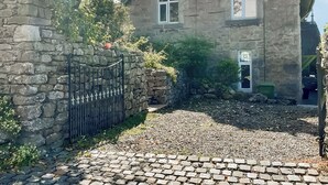 A stone house with a stone wall and a metal gate. - 3 bedroom accommodation in Arnside, near Grange-over-Sands (Arnside, near Grange-over-Sands)
