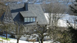 A house with a steeply pitched roof, dormer windows, and a visible chimney. - Apartment Oberkirchen - Ferienhaus Oberkirchen (Schmallenberg)