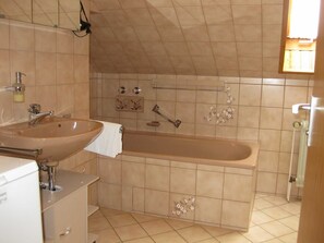 Ein Badezimmer mit einem beigen Waschbecken, einer Badewanne und einer Dusche.