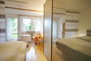 A bedroom with two beds, a small round table, and a chair. - Holiday Oasis - Apartment No. 4 - Holiday oasis (Bad Dürrheim)