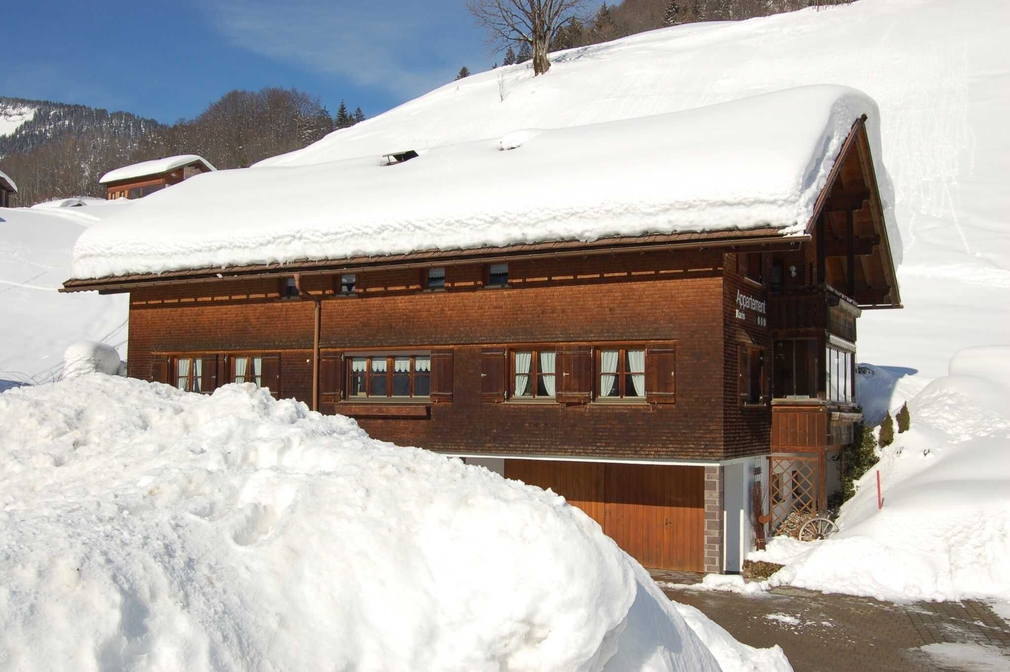 A chalet-style building with a sloped roof, wooden exterior, and multiple windows.
