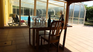A sunlit patio with a glass-enclosed dining area overlooking a swimming pool. - Zen Vouga - Quinta do Fundo de Vila (Oliveira de Frades)