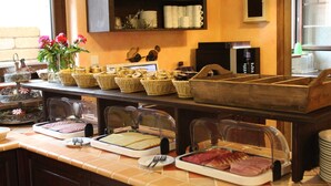 A buffet setup with various food items and a coffee station. - Two-Bedroom Apartment (4) - Pension Vanii (Rust)