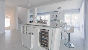 A modern kitchen with a central island, white cabinetry, and stainless steel appliances. - Villa Compass Luxury in a natural bay (Rogoznica)