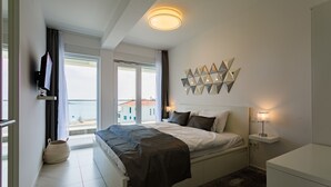 A modern bedroom with a bed, bedside table, and a wall-mounted TV. - Villa Compass Luxury in a natural bay (Rogoznica)