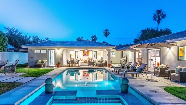 Uma casa moderna com piscina, móveis de exterior e área de varanda.