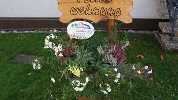 A wooden sign with the text "Fertig gemacht" in a garden setting.