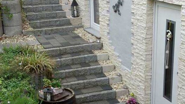 A set of stone steps leading to a door with a small porch area. - Four-bed room - Gästehaus Claudia (Rust)
