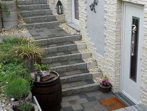 A set of stone steps leading to a door with a small porch area. - Four-bed room - Gästehaus Claudia (Rust)