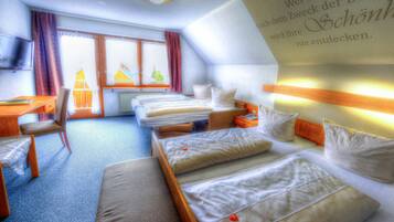 Une chambre d’hôtel équipée d’un lit, d’un bureau, d’une chaise et d’un téléviseur.