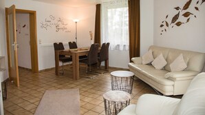 Un salon moderne comprenant un coin repas, un canapé et une table basse.
