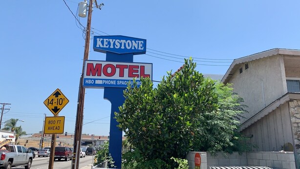 Ein Schild eines Motels mit der Aufschrift 'Keystone' und 'Motel', sowie ein Höhenbeschränkungszeichen mit 3,60 Metern.