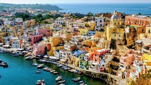 Un pueblo costero con edificios coloridos, un puerto con barcos e iglesia destacada.