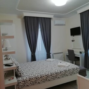 Kamar Quadruple Deluks | Seprai premium, selimut bulu angsa, dan tempat tidur Select Comfort