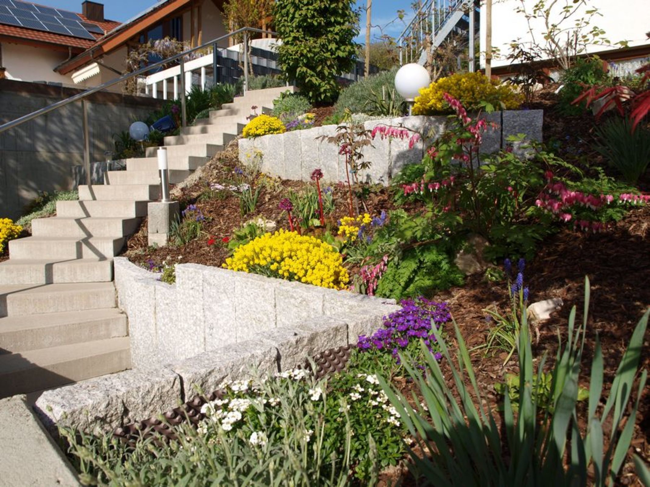 Una escalera que conduce a una casa con jardín delantero.
