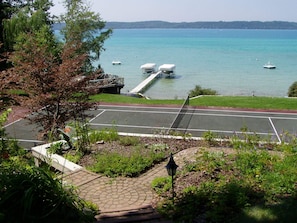 A waterfront view with a dock, a parking area, and a pedestrian path.